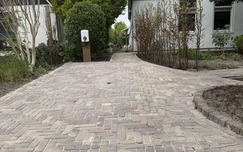 Gebogen tuinpad van oud gebakken klinkers, in halfsteens verband gelegd