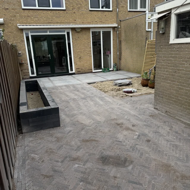 Overzicht van de bestrating met de plantenbak en de terrasdeuren